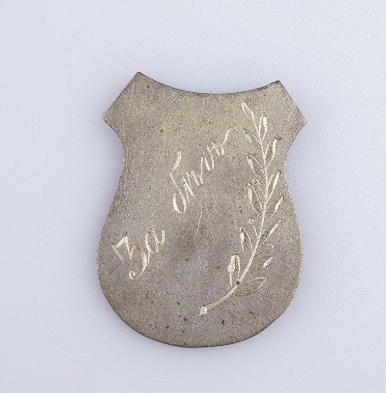 Silbernes Abzeichen mit einem Lorbeerkranz und der Inschrift "50. Hochzeitstag" auf einem weißen Hintergrund.