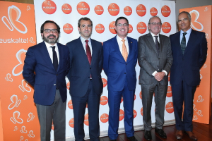 Eine Gruppe von Männern, die für ein Foto posieren und hinter ihnen Schilder mit dem Namen einer Organisation halten.