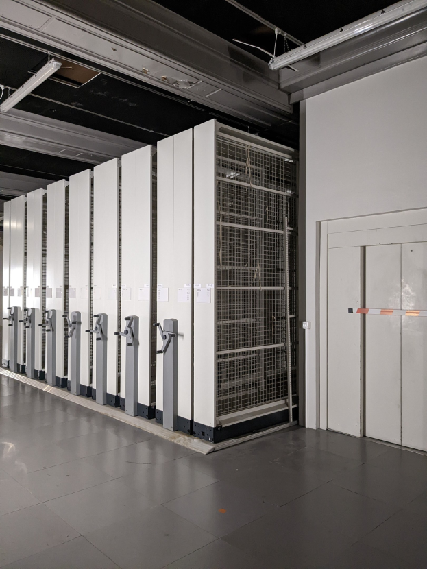 Gro├če R├Ąumlichkeit mit zahlreichen Servern in einem Rechenzentrum, mit einem Boden, einer Wand auf der rechten Seite und Deckenleuchten.