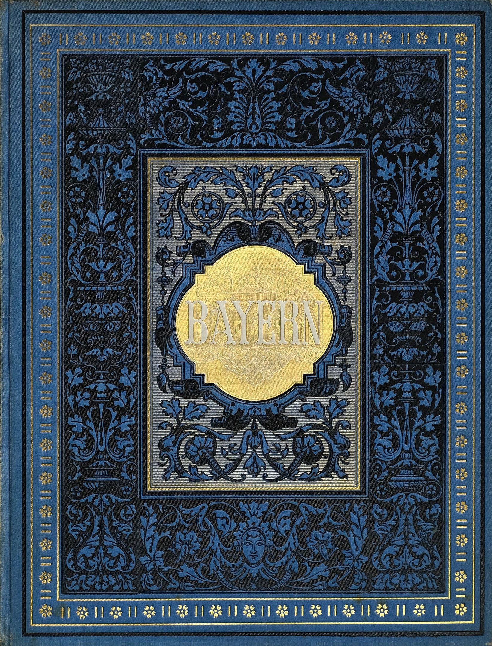 Ein blau-goldenes Buch mit dem Wort "Bayern" auf dem Cover, das mit kunstvollen Verzierungen versehen ist.