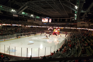 Ein Eishockeyspiel im Columbus Blue Jackets Stadion, mit Zuschauern auf den Tribünen und in der Nähe des Spielfelds, umgeben von Bannern und Deckenbeleuchtung.
