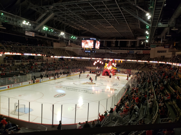 Ein Eishockeyspiel im Columbus Blue Jackets Stadion, mit Zuschauern auf den Tribünen und in der Nähe des Spielfelds, umgeben von Bannern und Deckenbeleuchtung.