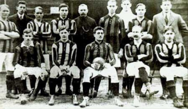 Schwarzes und weißes Foto der Fußballmannschaft des Ballymena Football Club, einige stehen, andere sitzen, vor einer Wand.