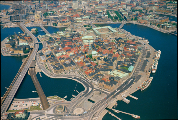 Luftaufnahme von Kopenhagen, Dänemark, mit Gebäuden, Straßen, Brücken und Schiffen auf dem Wasser und Text am unteren Rand des Bildes.