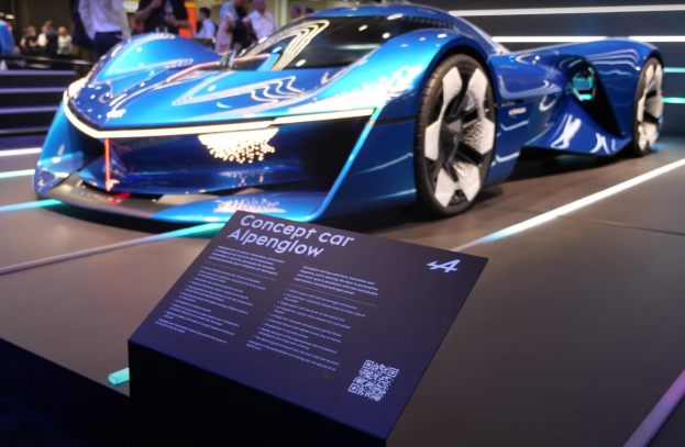 Blue Alpenglow-Konzeptauto auf der IAA in Frankfurt ausgestellt, mit Menschen im Hintergrund und einer Informationswand mit Text und QR-Code davor.
