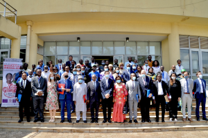 Gruppe von Menschen in Masken, die auf einer Treppe vor einem Gebäude mit Glaswänden und Säulen stehen, bei der Einweihung der ersten afrikanischen Initiative für die Gesundheit von Frauen