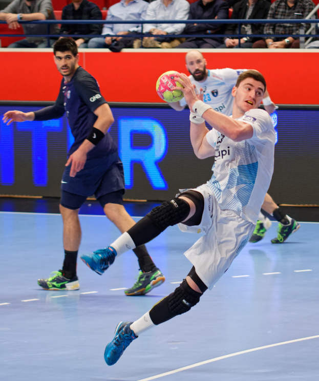 Eine Gruppe von Männern, die auf einem Handballfeld während der Futsal-Weltmeisterschaft 2019 spielen, mit Zuschauern im Hintergrund und einer Anzeigetafel mit den Spieltagen.