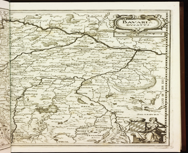 Ein aufgeschlagenes Buch, das eine detaillierte Karte von Bayern zeigt, einschließlich Städte, Ortschaften, Flüsse und geografische Merkmale, mit begleitendem Text, der zusätzliche Informationen bietet.