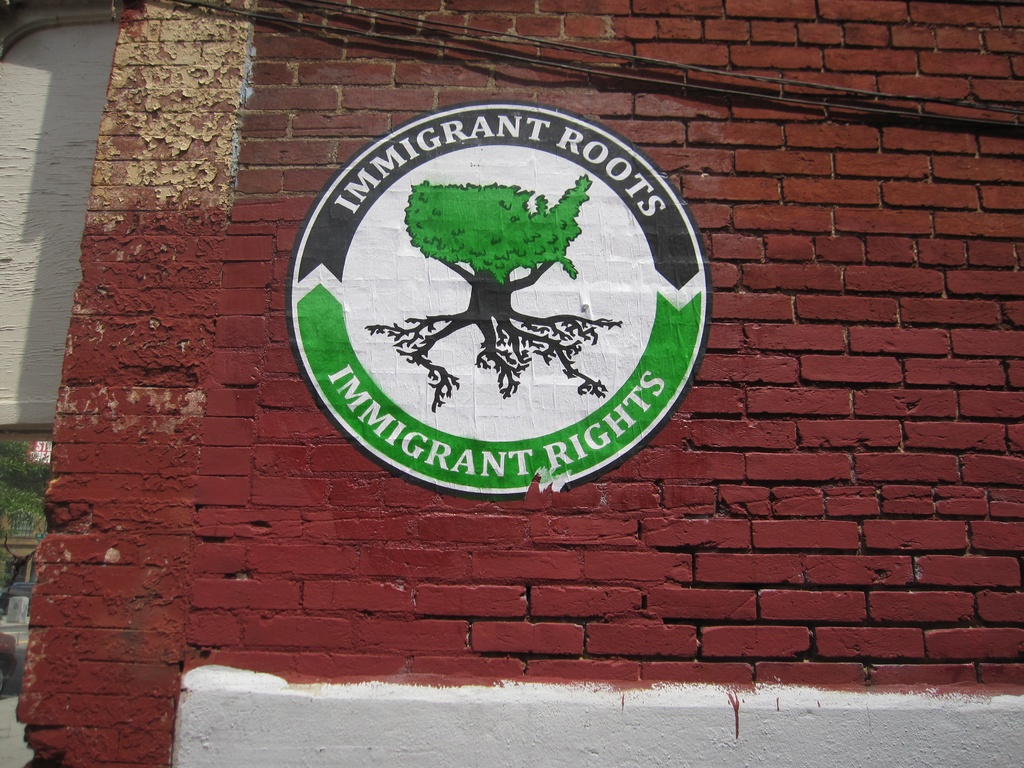 Ein Plakat an einer Backsteinwand.