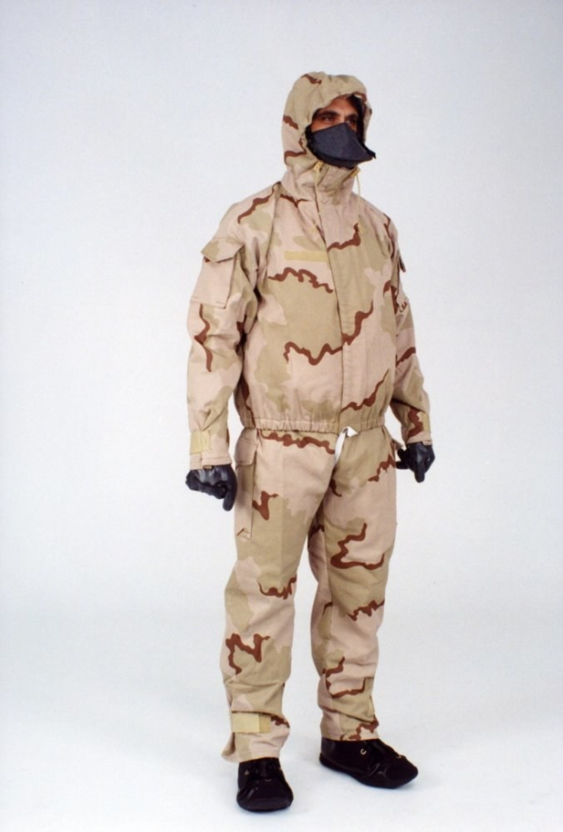 Ein Tarnmuster-Schutzoverall mit Kapuze und Maske, der für den Schutz vor gefährlichen Materialien entworfen wurde und von einer Person gegen einen weißen Hintergrund getragen wird.