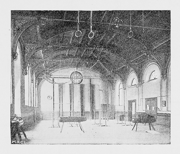 Schwarzes und weißes Foto eines großen Turnhallen mit Tischen, Stühlen, Säulen, Wänden, Fenstern und Deckenringe beschriftet "New York City Gymnasium".