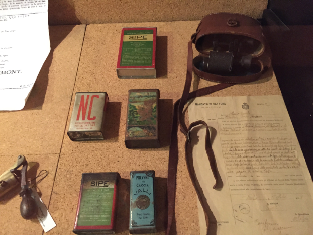 Eine Korktafel mit verschiedenen daran befestigten Gegenständen, darunter Kartons, Papiere und eine Tasche.